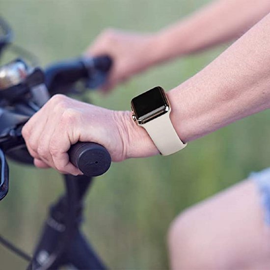Lichtbeige siliconen bandje om een smartwatch, gedragen door een persoon die fietst.