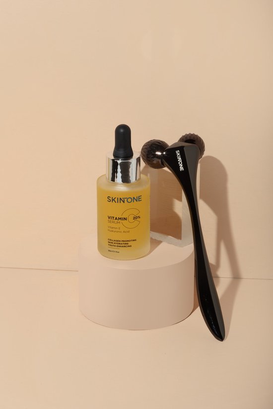 Glazen flesje SKINONE vitamine C serum met druppelaar en een zwarte dermaroller met twee wieltjes.