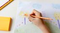 Hand kleurt met een oranje BIC Kids Illusion potlood een boom, naast gele post-its.