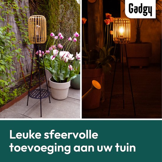 Rotan lantaarn op driepoot in de tuin bij daglicht en 's avonds. Leuke toevoeging.