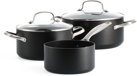 Zwarte pannenset met glazen deksels en metalen handgrepen op zwarte achtergrond.