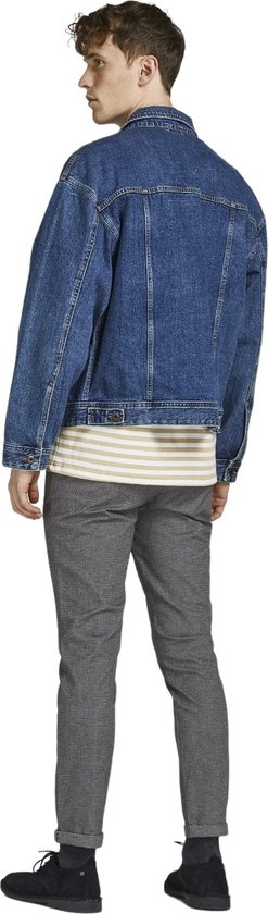 Model van achteren in grijze broek met visgraatpatroon, gestreepte top en spijkerjack.