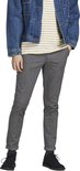 Model in grijze broek met visgraatpatroon, gestreepte top en spijkerjack.