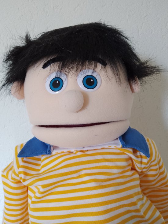 Gezicht van een buikspreekpop met zwart haar, blauwe ogen en een gele gestreepte trui.