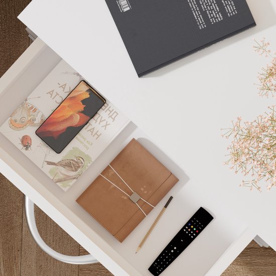 Open lade met telefoon, notitieboek, potlood, afstandsbediening en boeken.