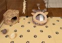 Een beige fleece liner met pootjesprints en een giraffen-huisje in een ren.