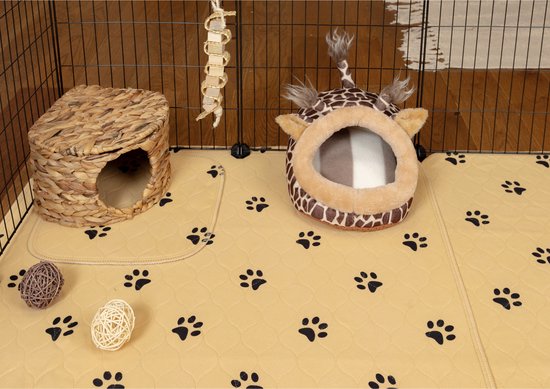 Een beige fleece liner met pootjesprints en een giraffen-huisje in een ren.