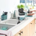 Keuken aanrecht met donkergrijs afvalbakje, vaatwasser en groenten.