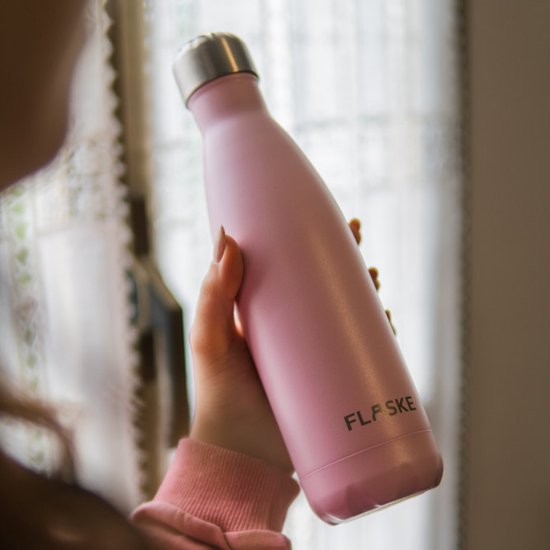 Vrouw met een roze FLASKE drinkfles in haar handen.