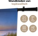 Wandkleed van topkwaliteit met afbeelding van een zonsondergang aan zee, inclusief icoontjes over producteigenschappen.
