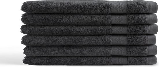 Pile de six gants de toilette anthracite texturés.