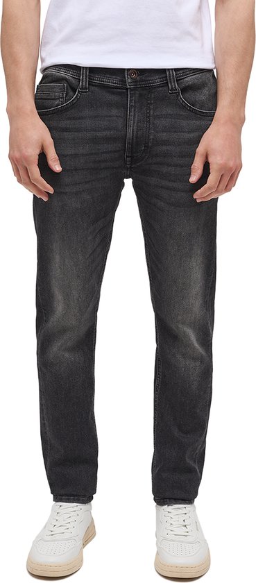 Man met een zwarte Mustang OREGON SLIM K jeans, wit T-shirt en witte sneakers.