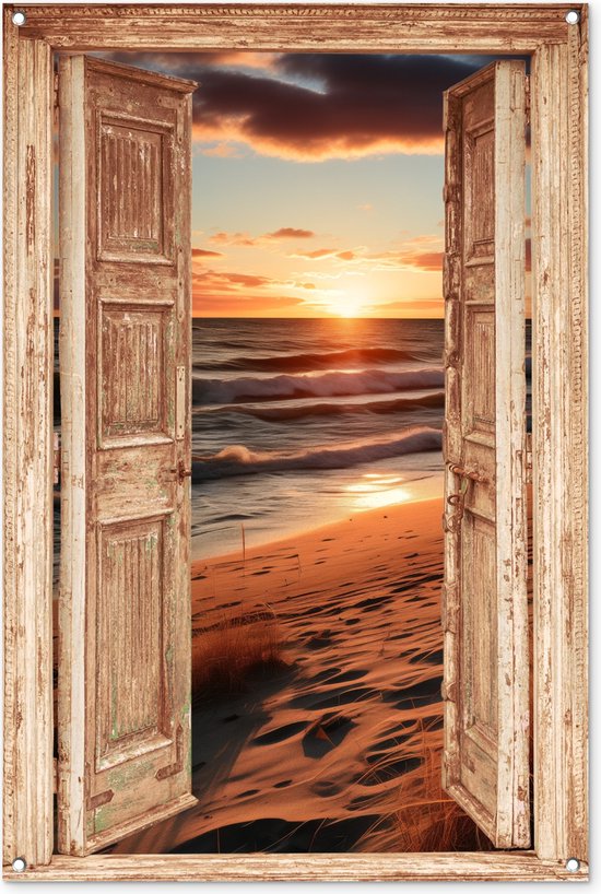 Een open, verweerde deur met uitzicht op een zonsondergang op het strand, met golven en duinen.