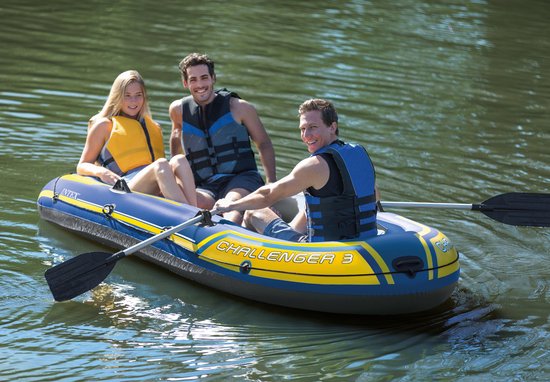 Drie mensen in een blauwe Intex Challenger 3 boot met gele strepen op het water.