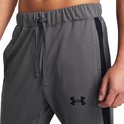 Grijze trainingsbroek met trekkoord, zwarte streep op de zijkant en een zwart Under Armour logo.