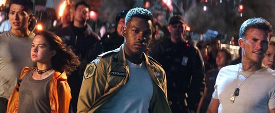 Acteurs John Boyega, Scott Eastwood en Cailee Spaeny in het midden van een menigte, met op de achtergrond vuur.