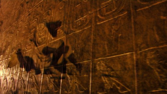 Schaduwen van figuren op een muur met oude Egyptische hiërogliefen.