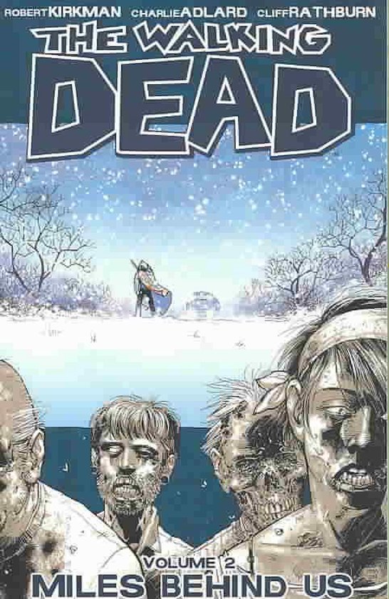 De cover van The Walking Dead Volume 2: Miles Behind Us. Zombiegezichten op de voorgrond, besneeuwd landschap met een figuur op de achtergrond.