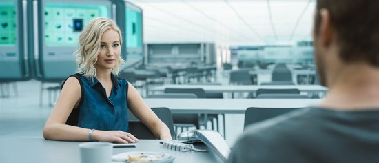 Jennifer Lawrence in blauwe top zit aan tafel in een kantine.