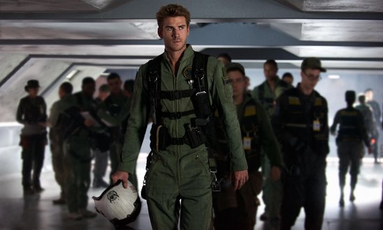 Een man in een pilotenpak met helm, omringd door soldaten.