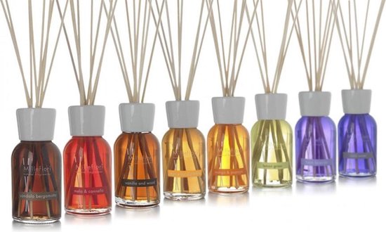Rij van acht Millefiori Milano diffusers in diverse kleuren bruin, rood, oranje, geel en paars met witte doppen en stokjes.