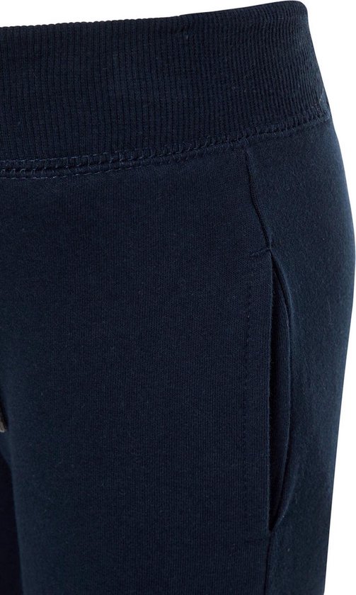 Detail van de zak en tailleband van een donkerblauwe joggingbroek.