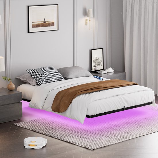 Bed met wit beddengoed, bruine sprei en paarse led-verlichting onder het zwevende frame.