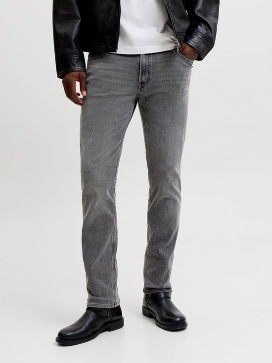 Detail van grijze jeans met zwarte laarzen.