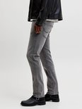 Detail van grijze jeans met zwarte laarzen.