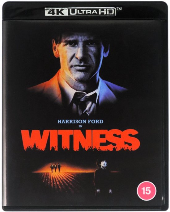 Blu-ray hoes met Harrison Ford boven de titel WITNESS in rode, uitlopende letters. Onderin een boerderijlandschap.