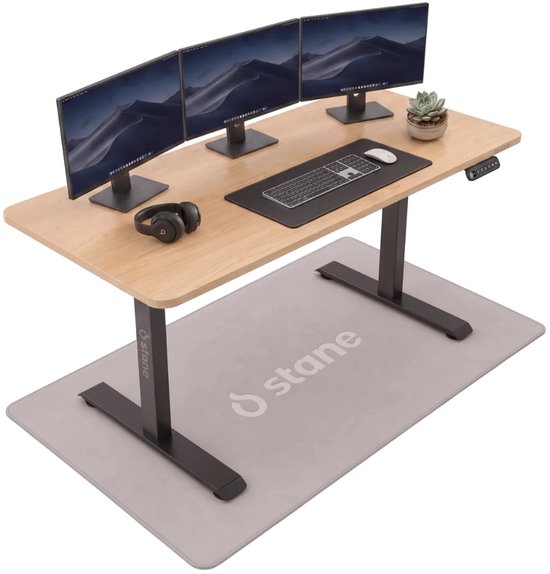 Elektrisch verstelbaar bureau van Stane met eiken blad, drie monitoren, toetsenbord, muis, koptelefoon en plantje.