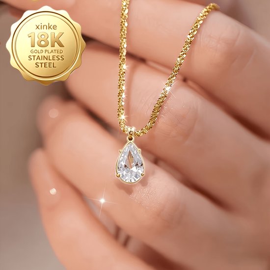 Chaîne dorée avec un pendentif en zircone en forme de goutte, portée par une main.