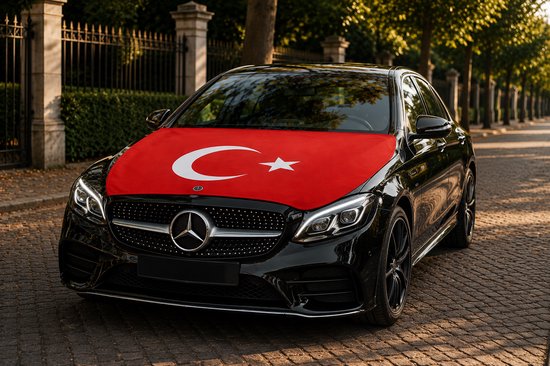Zwarte Mercedes-Benz met Turkse vlag op de motorkap, geparkeerd op een geplaveide straat met bomen.