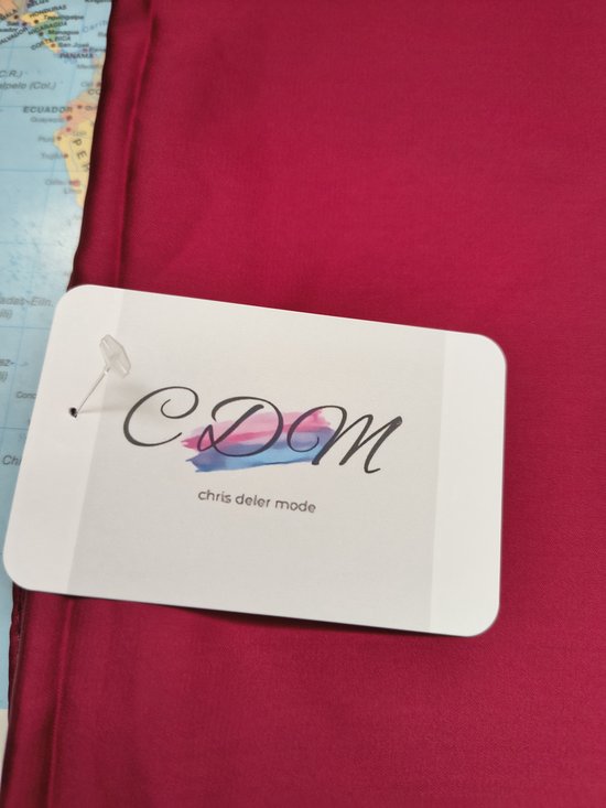 Kamerik detail van een kledinghanger met het logo 'chris deler mode'.