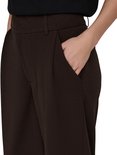 Dames in bruine wijde broek, detail van de broekzak.