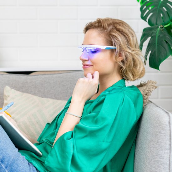 Vrouw met AYO bril gebruikt blauw licht tijdens het schrijven.