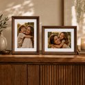 Twee bruine houten fotolijsten met foto's van moeders en kinderen omhelzend.