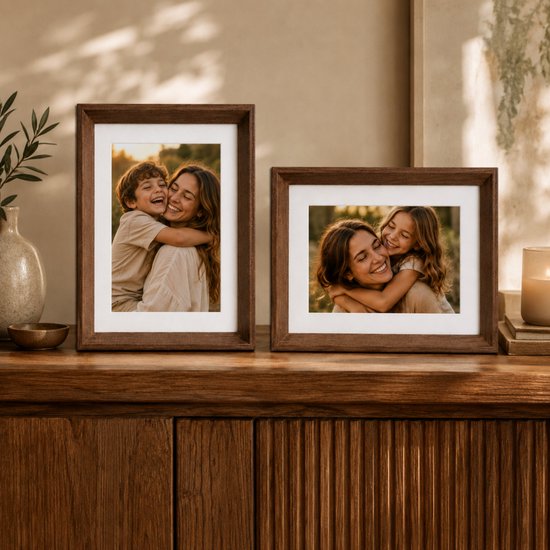 Twee bruine houten fotolijsten met foto's van moeders en kinderen omhelzend.