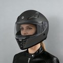 Matzwarte integraalhelm met getint vizier, gedragen door een vrouw met een zwarte leren jas.