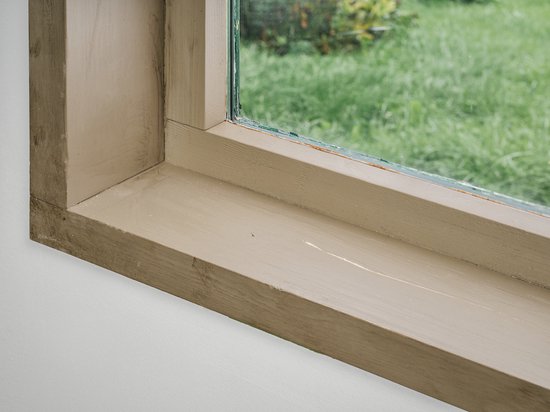 Houten vensterbank met vers aangebracht, wit, glad vulmiddel.