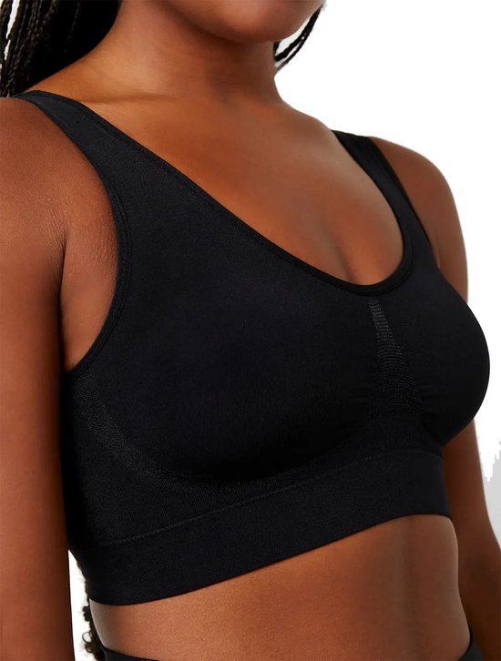Zwarte comfort beha met v-hals en brede bandjes, gedragen door een donkere vrouw.