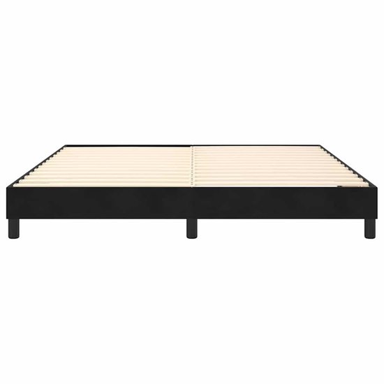 Een zwart boxspring frame met houten lattenbodem, staand op vier poten.