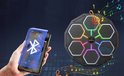 Octagonale bokstrainer met 6 led-panelen en muzieknoten. Een hand houdt een smartphone met Bluetooth-logo vast.