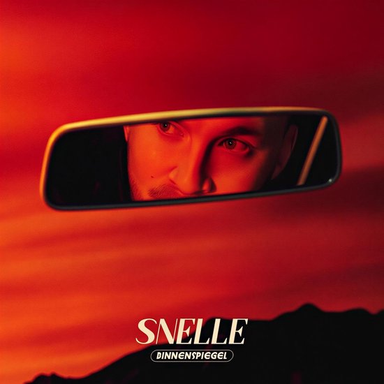 Binnenspiegel met de reflectie van een mannelijk gezicht in rood licht. Tittel "SNELLE DINNENSPIEGEL".