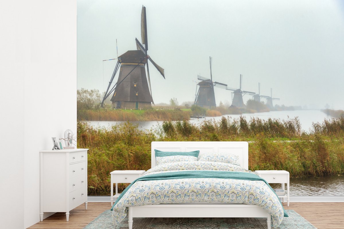 Behang - Fotobehang De eeuwenoude Molens van Kinderdijk in Nederland - Breedte 305 cm x hoogte 220 cm