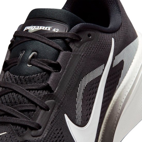 Detail van de voorkant van zwarte Nike Pegasus 42 hardloopschoen met witte veters en swoosh.
