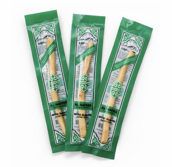 Drie Miswak tandenborstels in hun groene verpakking.