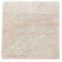 Vierkante beige badmat met een zachte, pluizige textuur.