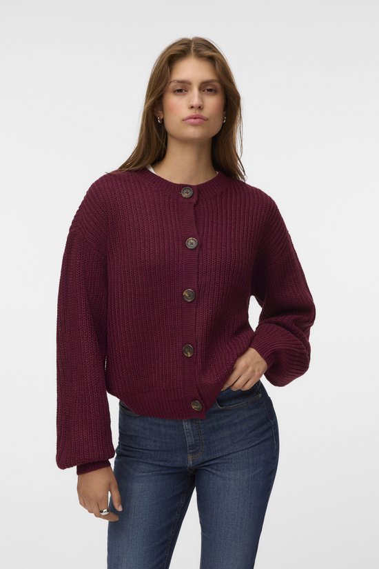 Model draagt bordeauxrode gebreide cardigan met knopen en ballonmouwen.