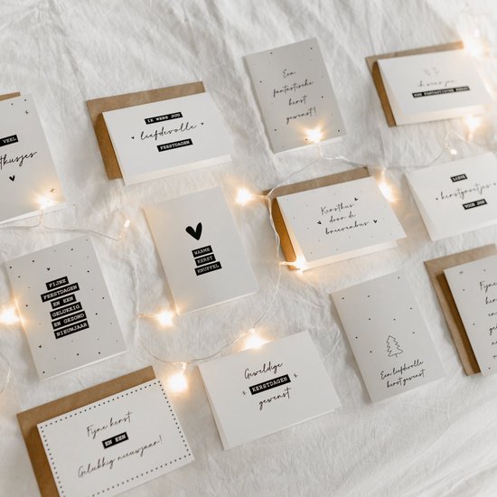 Set van twaalf kerst- en nieuwjaarskaarten, met diverse teksten en illustraties zoals hartjes en kerstbomen.